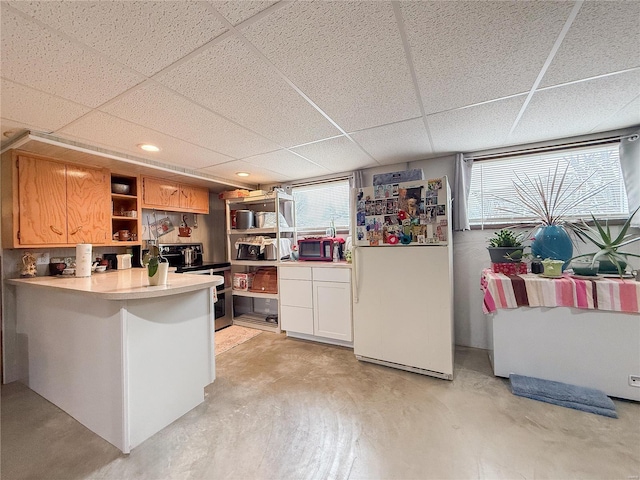 kitchen featuring freestanding refrigerator, a healthy amount of sunlight, double oven range, and open shelves