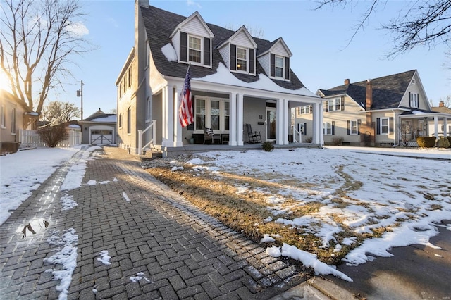 cape cod home with a garage and covered porch