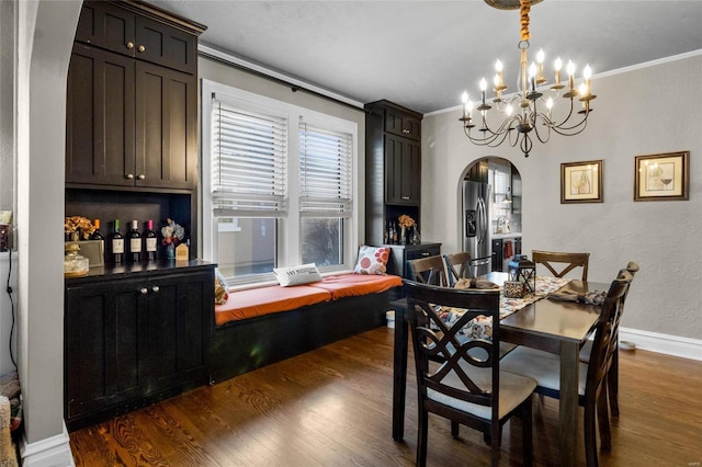 dining room featuring dark wood-type flooring, arched walkways, crown molding, and baseboards