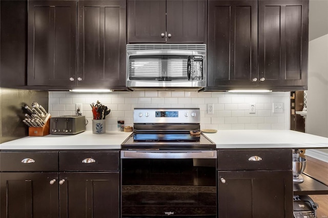 kitchen with light countertops, appliances with stainless steel finishes, backsplash, and dark brown cabinets