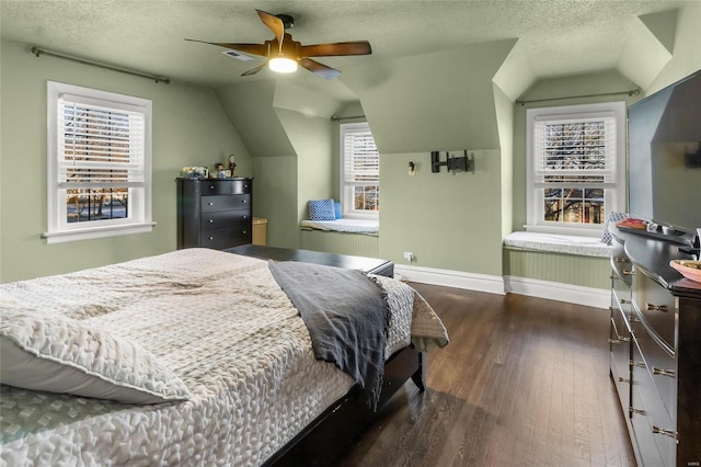 bedroom with dark wood finished floors, visible vents, vaulted ceiling, a textured ceiling, and baseboards