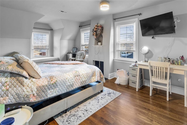 bedroom with dark wood-type flooring, lofted ceiling, multiple windows, and visible vents