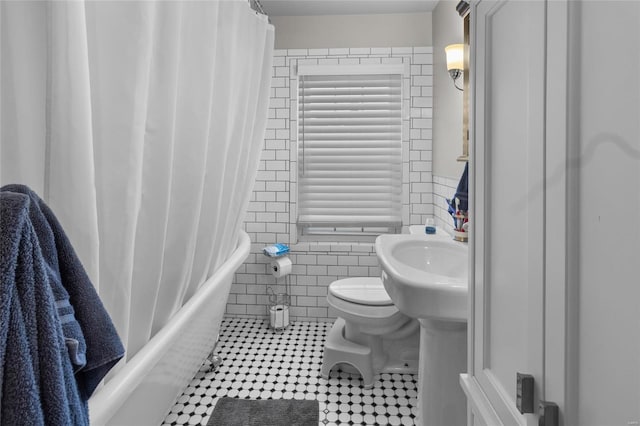 full bathroom featuring toilet, tile patterned flooring, tile walls, and shower / bathtub combination with curtain