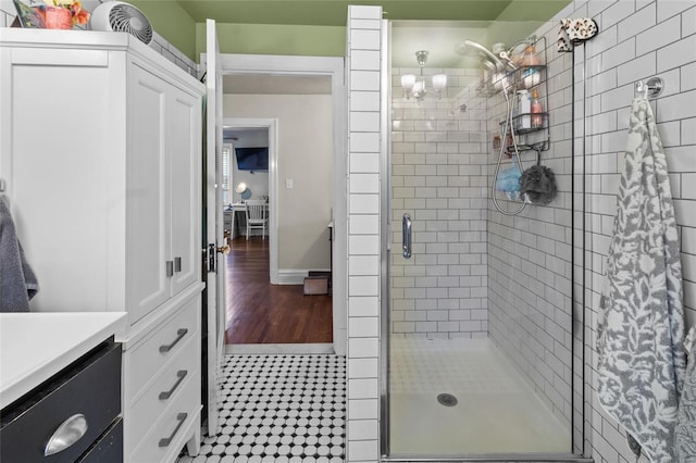 full bathroom featuring baseboards, a shower stall, vanity, and wood finished floors