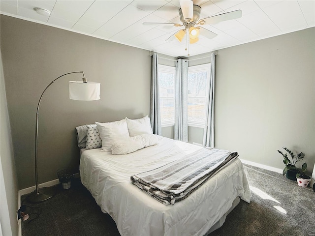 carpeted bedroom featuring baseboards and a ceiling fan