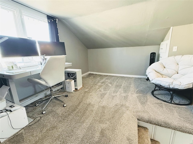 office space featuring lofted ceiling, light colored carpet, and baseboards