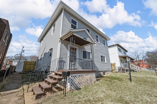 exterior space featuring covered porch, fence, and a lawn