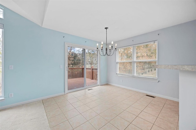 spare room featuring a healthy amount of sunlight, visible vents, baseboards, and an inviting chandelier