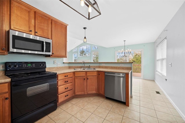 kitchen featuring a sink, light countertops, appliances with stainless steel finishes, brown cabinets, and pendant lighting