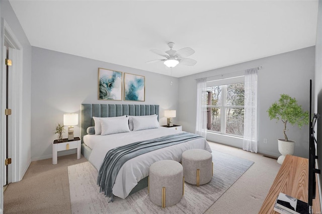 bedroom featuring baseboards, ceiling fan, and light colored carpet