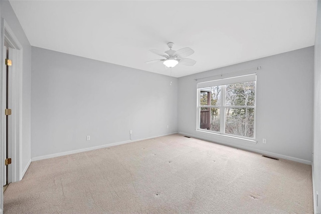 unfurnished room with ceiling fan, visible vents, baseboards, and light colored carpet