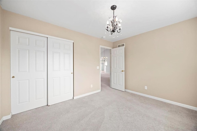 unfurnished bedroom with light carpet, visible vents, a chandelier, and baseboards