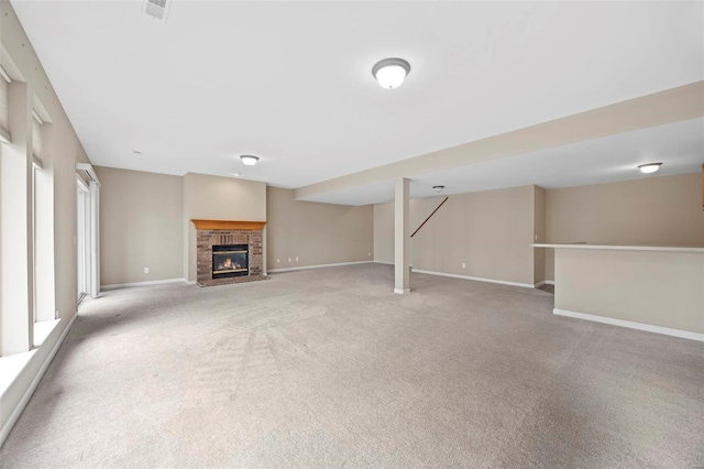 unfurnished living room featuring light carpet, a brick fireplace, visible vents, and baseboards