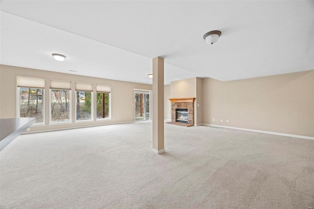 unfurnished living room featuring light carpet, a brick fireplace, and baseboards