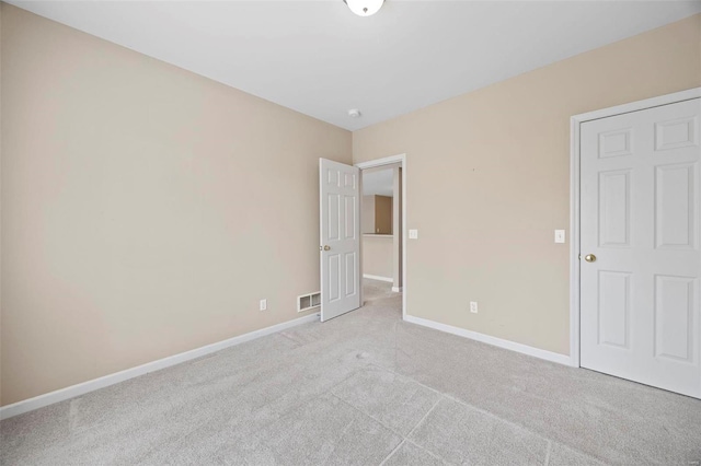 unfurnished bedroom with light carpet, visible vents, and baseboards