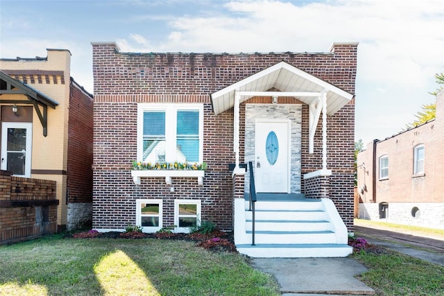 view of front of home featuring a front yard and brick siding