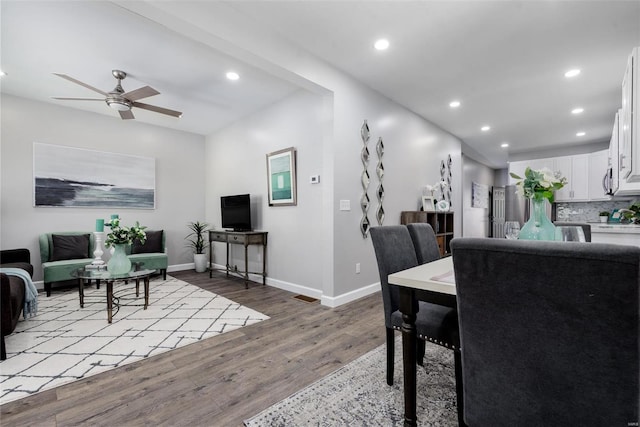 dining room with baseboards, light wood finished floors, a ceiling fan, and recessed lighting