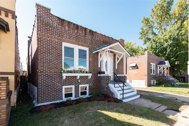 view of front facade featuring brick siding and a front yard