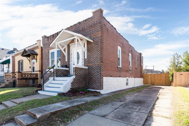 bungalow with fence and brick siding