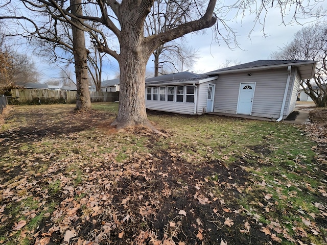 back of house featuring a yard and fence