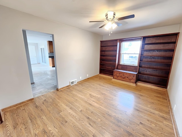 unfurnished room featuring light wood-style flooring, visible vents, and baseboards