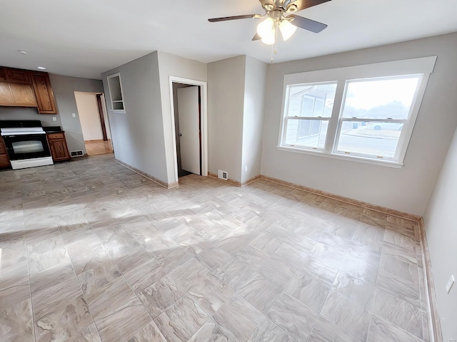 unfurnished living room featuring baseboards, visible vents, and ceiling fan