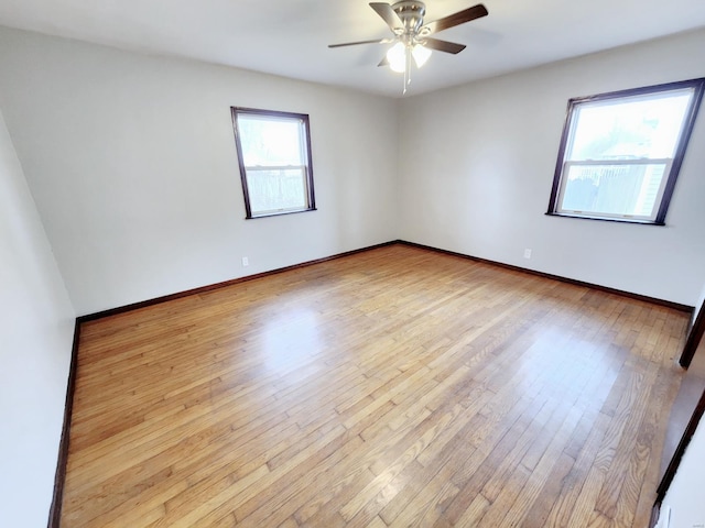 empty room featuring light wood-type flooring, ceiling fan, and baseboards