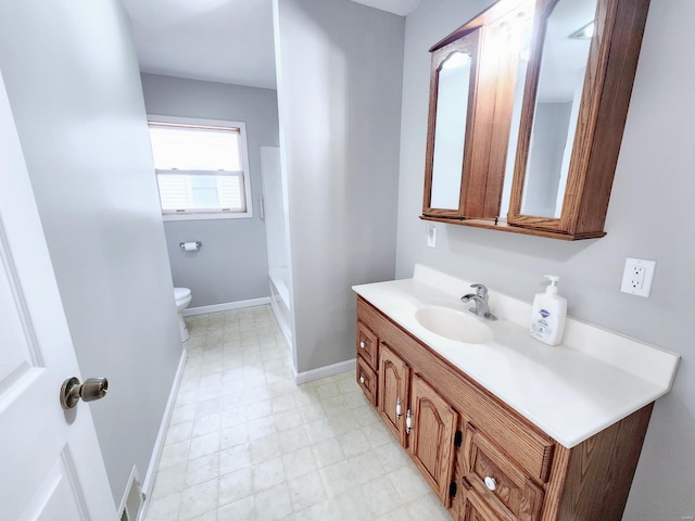 full bathroom with toilet, vanity, baseboards, and tile patterned floors