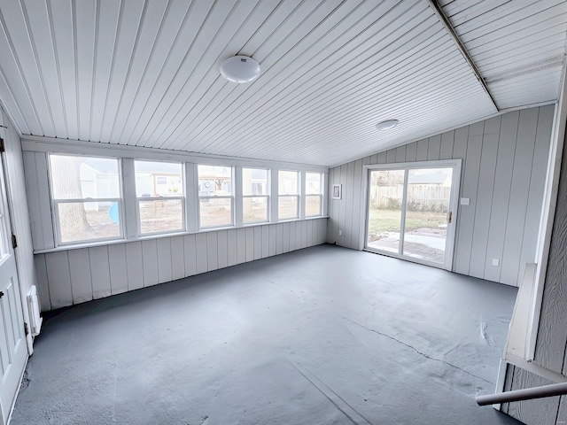 unfurnished sunroom featuring lofted ceiling and radiator