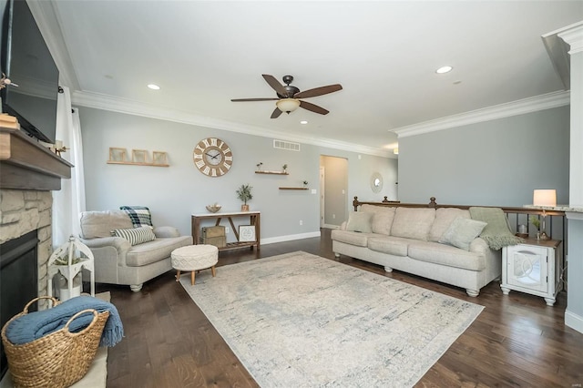 living room featuring a stone fireplace, dark wood-type flooring, recessed lighting, and visible vents