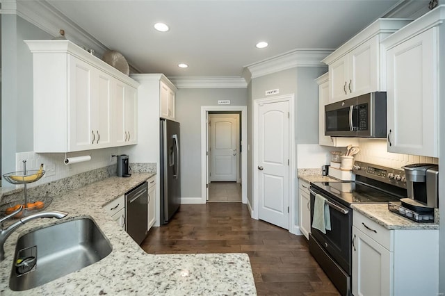 kitchen with dark wood finished floors, a sink, stainless steel appliances, white cabinets, and crown molding