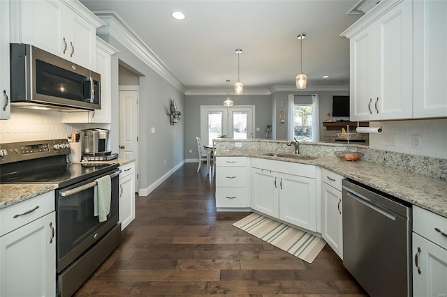 kitchen featuring ornamental molding, a sink, tasteful backsplash, stainless steel appliances, and a peninsula