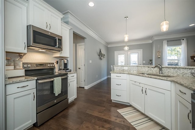 kitchen featuring a sink, backsplash, appliances with stainless steel finishes, and ornamental molding