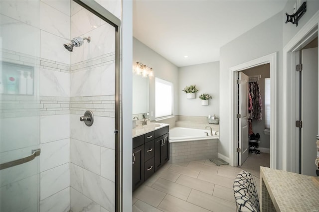 full bath featuring tile patterned floors, vanity, a bath, and a shower stall