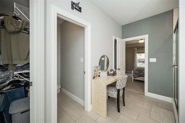 ensuite bathroom featuring connected bathroom, baseboards, and an enclosed shower