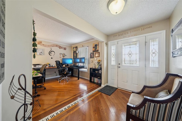 foyer featuring plenty of natural light, a textured ceiling, baseboards, and wood finished floors