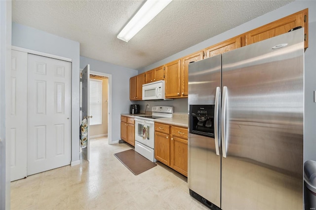 kitchen featuring a textured ceiling, white appliances, baseboards, light countertops, and brown cabinets