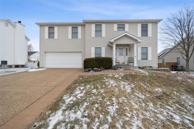 view of front of property featuring concrete driveway, an attached garage, and cooling unit