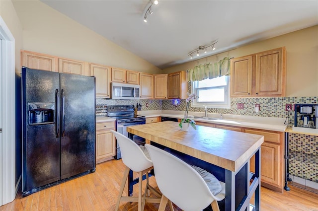 kitchen with light brown cabinets, stainless steel microwave, black fridge with ice dispenser, and electric range oven