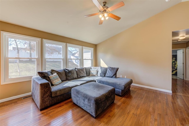 living area with plenty of natural light, visible vents, vaulted ceiling, and hardwood / wood-style flooring