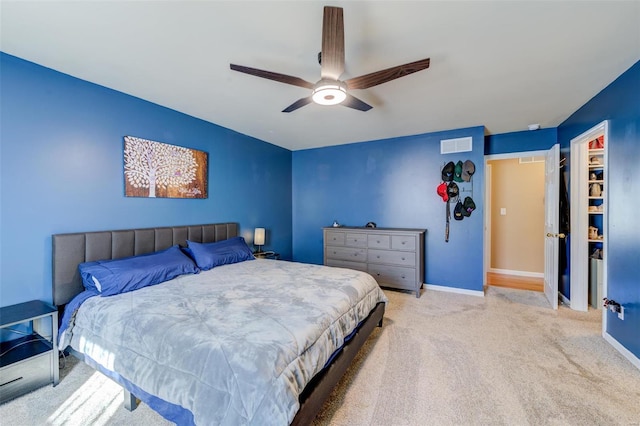 carpeted bedroom with a ceiling fan, visible vents, and baseboards