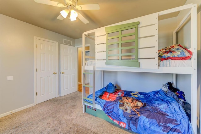 carpeted bedroom featuring baseboards, visible vents, and a ceiling fan