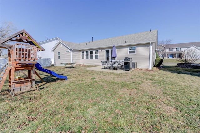 back of house with a patio area, a yard, and a playground