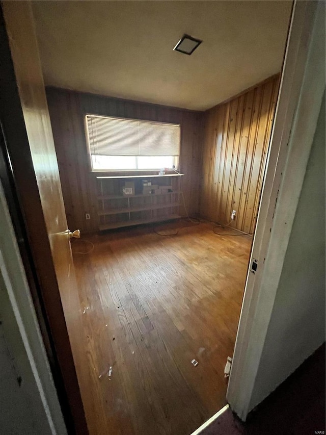 spare room featuring wood walls and wood finished floors