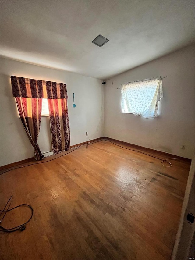 unfurnished room featuring baseboards and wood finished floors