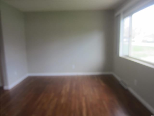 unfurnished room with wood finished floors and baseboards