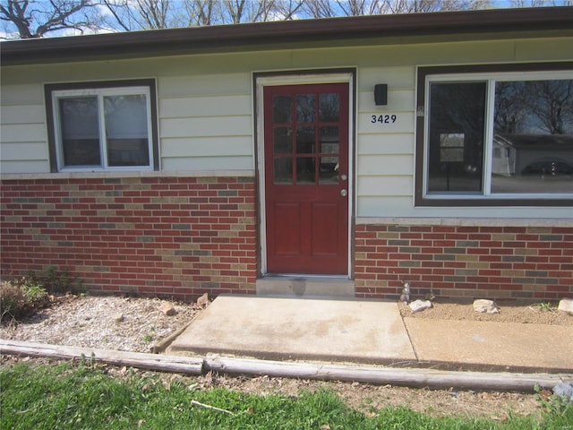 doorway to property with brick siding