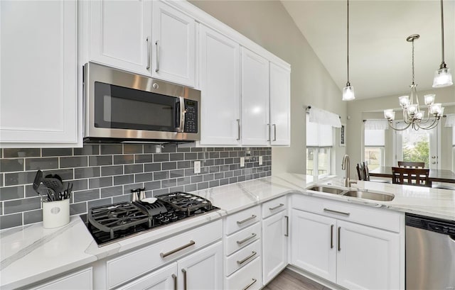 kitchen featuring decorative backsplash, white cabinetry, stainless steel appliances, and a sink