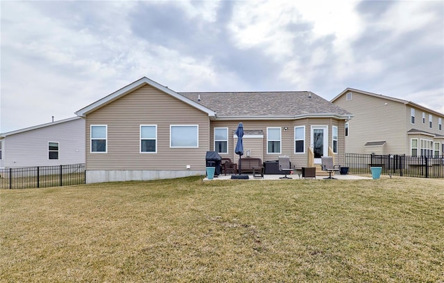 rear view of property featuring roof with shingles, a patio area, a yard, and fence