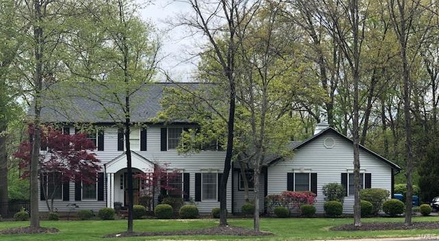 colonial inspired home featuring a front lawn